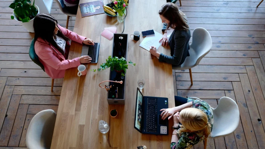Top view of diverse individuals collaborating at a table, illustrating teamwork in a startup environment.