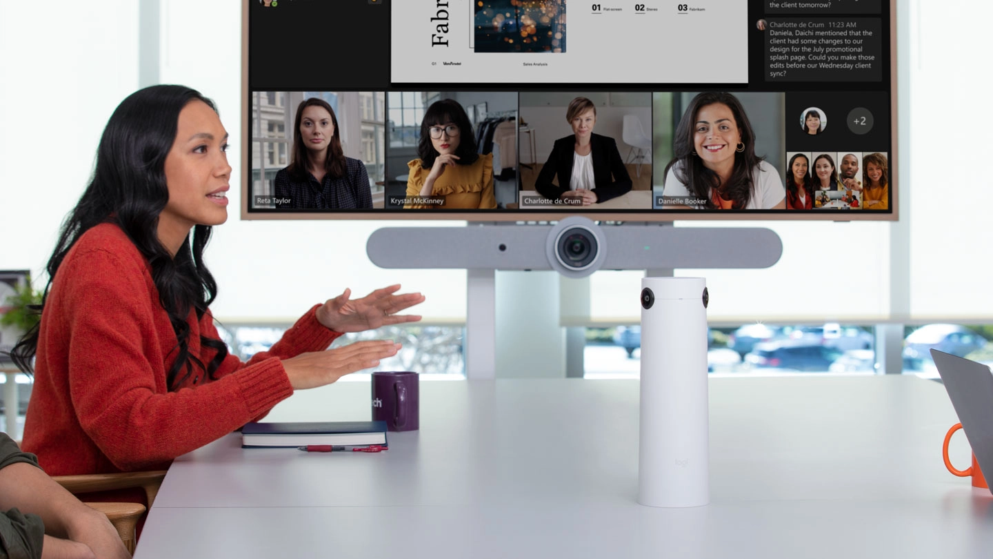 An image of an online meeting between onsite and remote coworkers using an AV wall in small room that can seat up to eight.